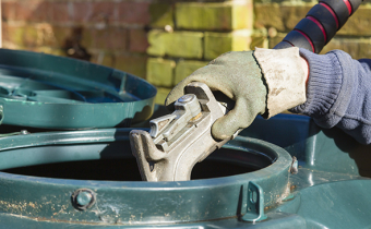 Closeup of man filling a bunded oil tank with domestic heating oil (kerosene) at a house in rural England.